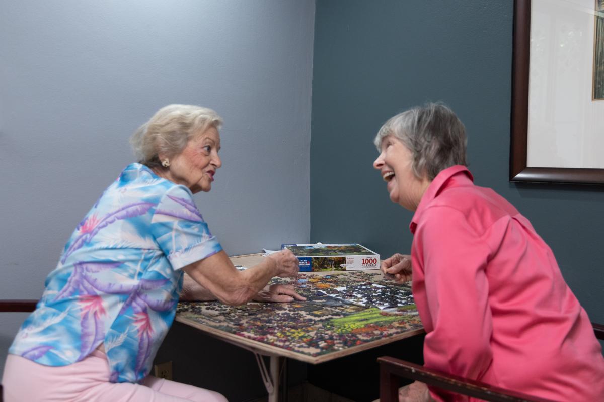 two women happily doing a puzzle