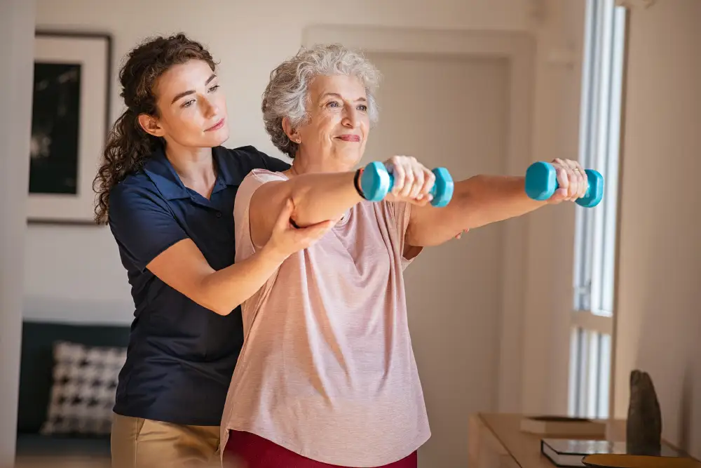 a senior woman lifting weights with the help of a personal trainer