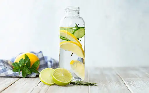 a bottle of water with slices of lemon and lime in it